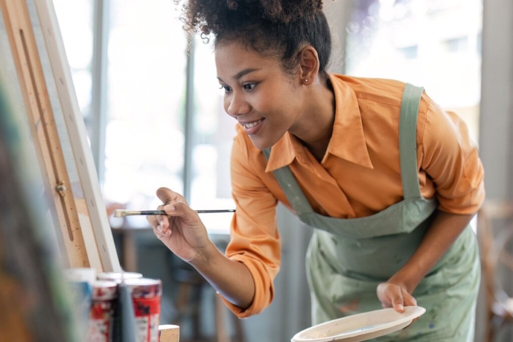 Mulher pintando um quadro no cavalete