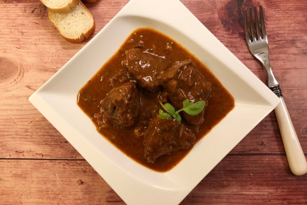 Coxão duro com vinho tinto  em um prato branco 