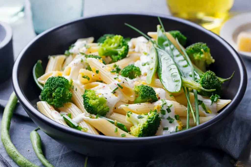 Macarrão com brócolis e molho branco em uma panela preta