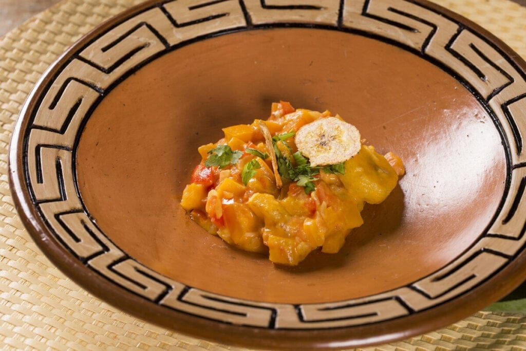 Prato marrom com moqueca de banana-da-terra