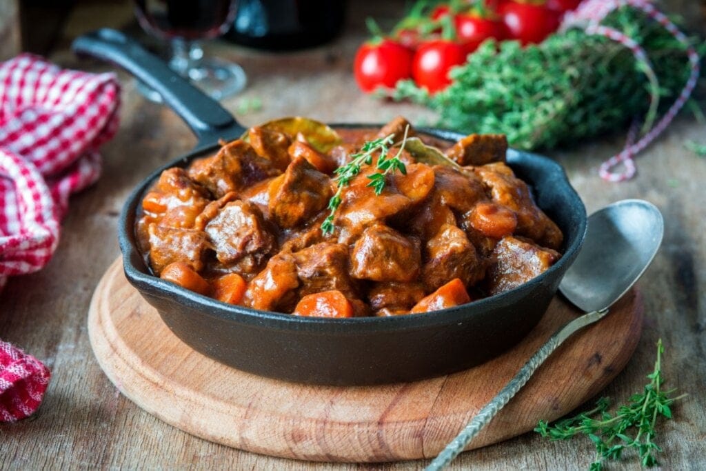 Carne de cenoura servida em panela de ferro servido em tábua de madeira em cima da mesa