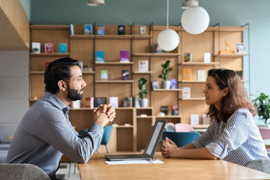 Mulher sendo entrevistada por recrutador em empresa