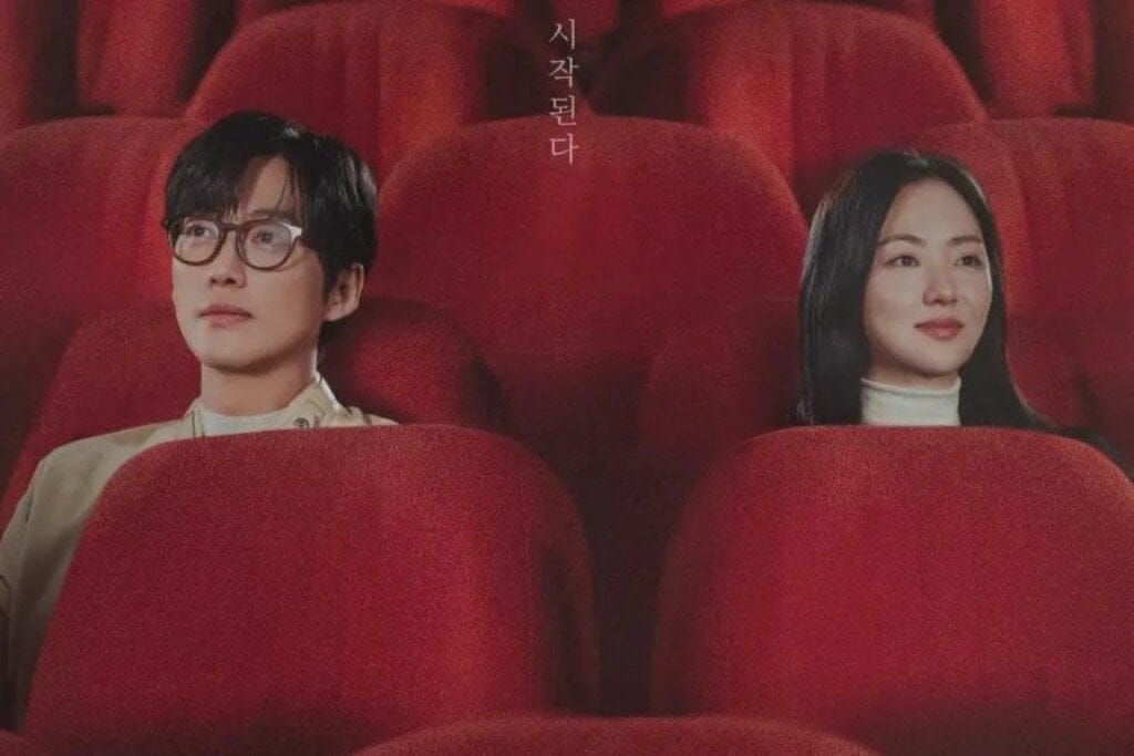 Homem e mulher sentados em poltronas vermelhas em uma sala de cinema 