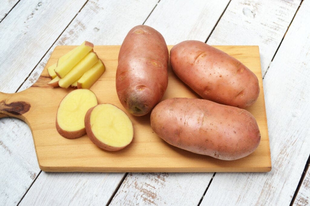 Batata asterix inteira e cortada em cima de tábua