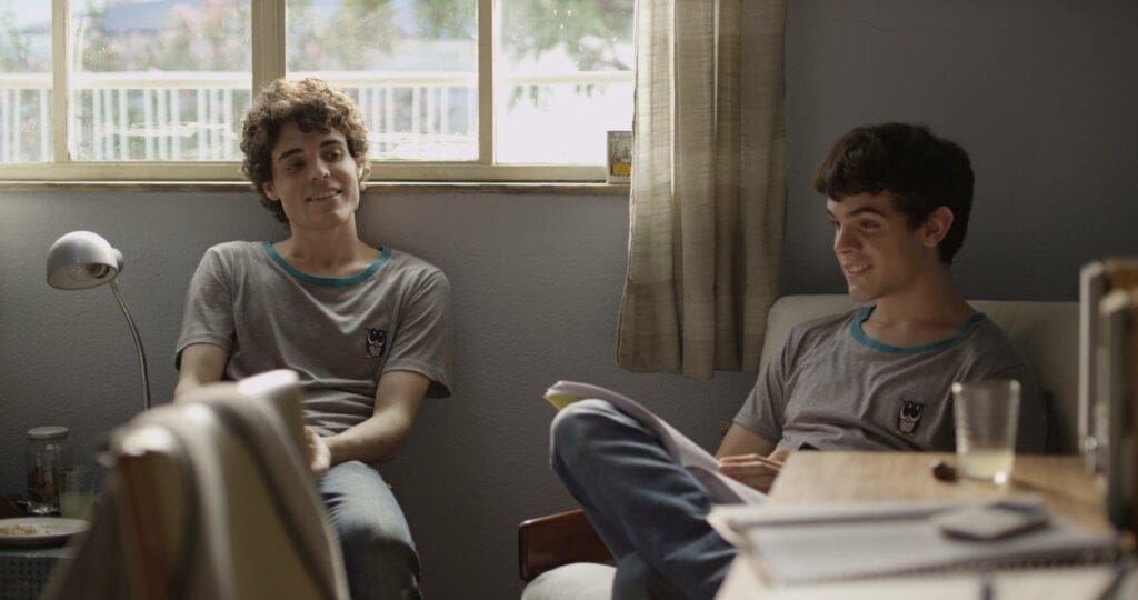 Dois meninos sentados conversando. Cena do filme "Hoje eu quero voltar sozinho".