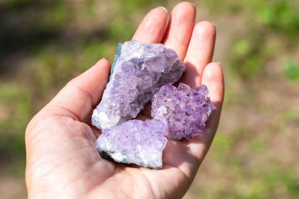 Pedra ametista na cor roxa em palma de mão