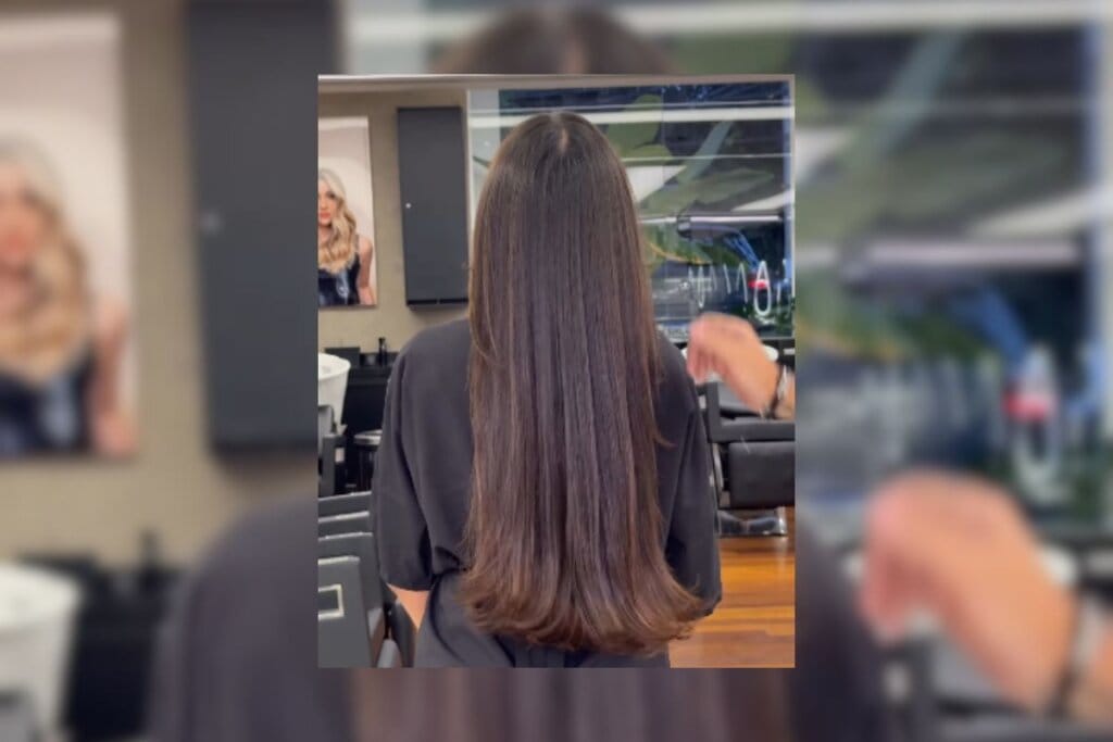 Mulher com cabelo longo e com mechas em chocolate virada de costas mostrando os cabelos