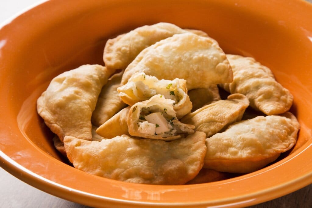 Pastéis de palmito em prato fundo laranja