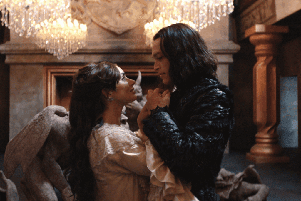 Casal dançando, ambos estão usando roupas de epoca, a mulher com roupas em tons claros e o homem usando roupas pretas 