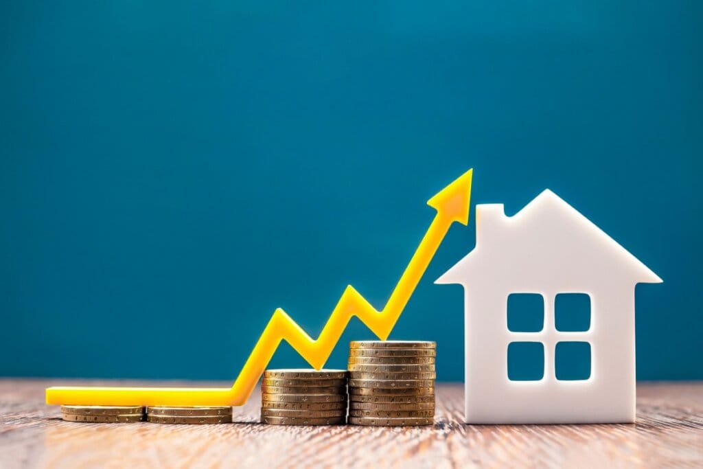 Modelo de casa e uma pilha de moedas
