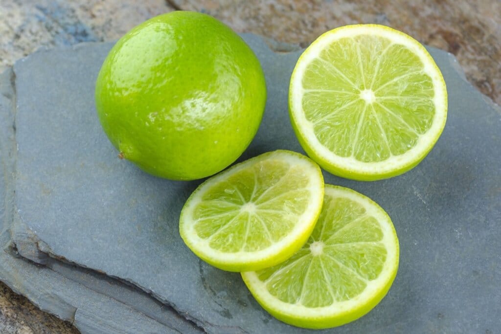 Limão-taiti em cima de pedra em cima de mesa de madeira 