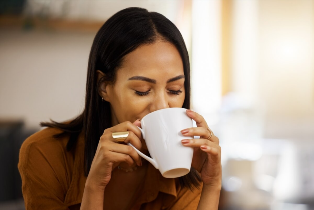 Mulher bebendo chá em caneca branca