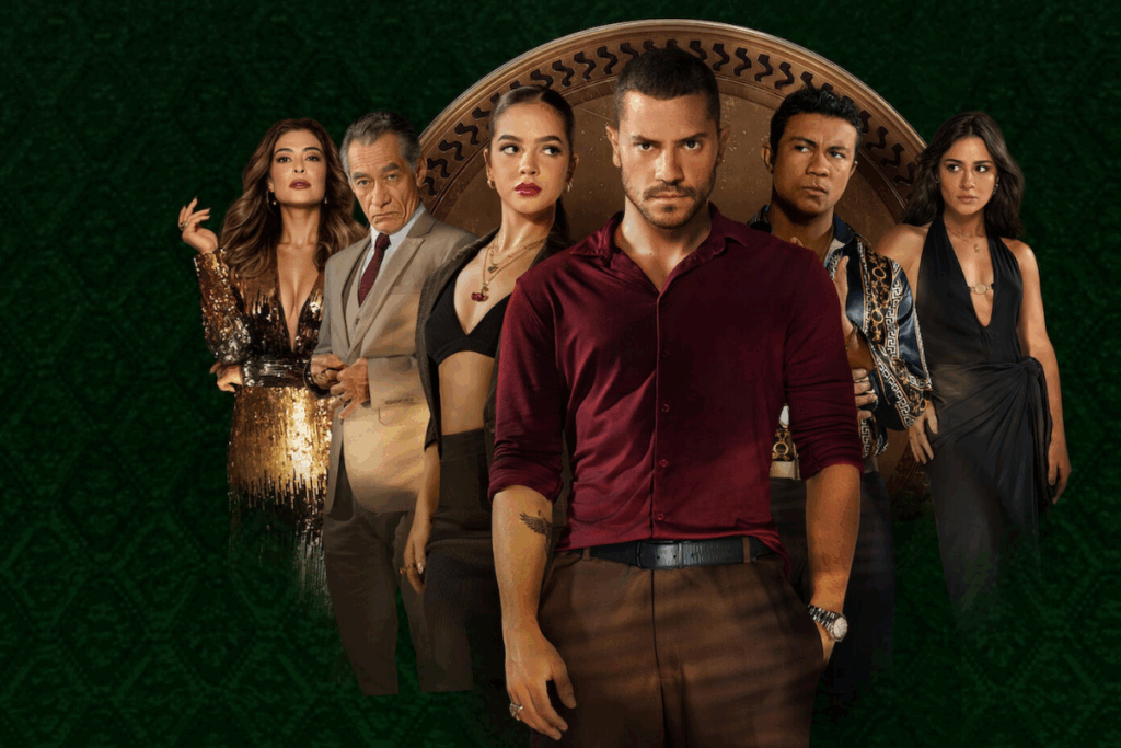 Imagem de um homem no centro com cabelo curto, barba e usando camisa vinho e calça marrom e ao fundo imagens de outras 3 mulheres, 2 usando preto e 1 usando vestido de paetê, e dois homens um usando terno e gravate cinza e outro uma camisa preta estampada