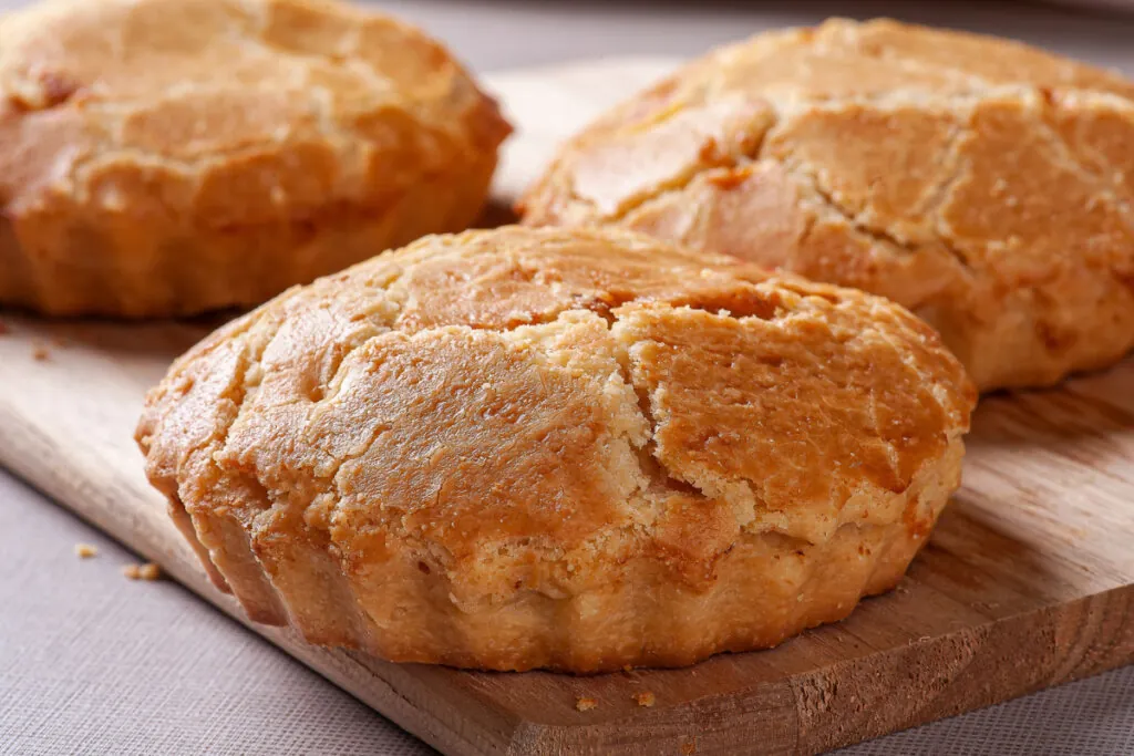 Três empadas grandes em cima de tábua