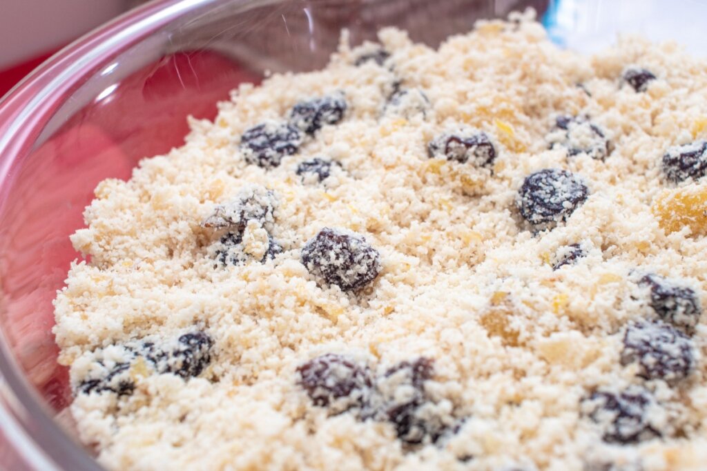 Farofa com uva-passa e damasco servida em tigela grande de vidro