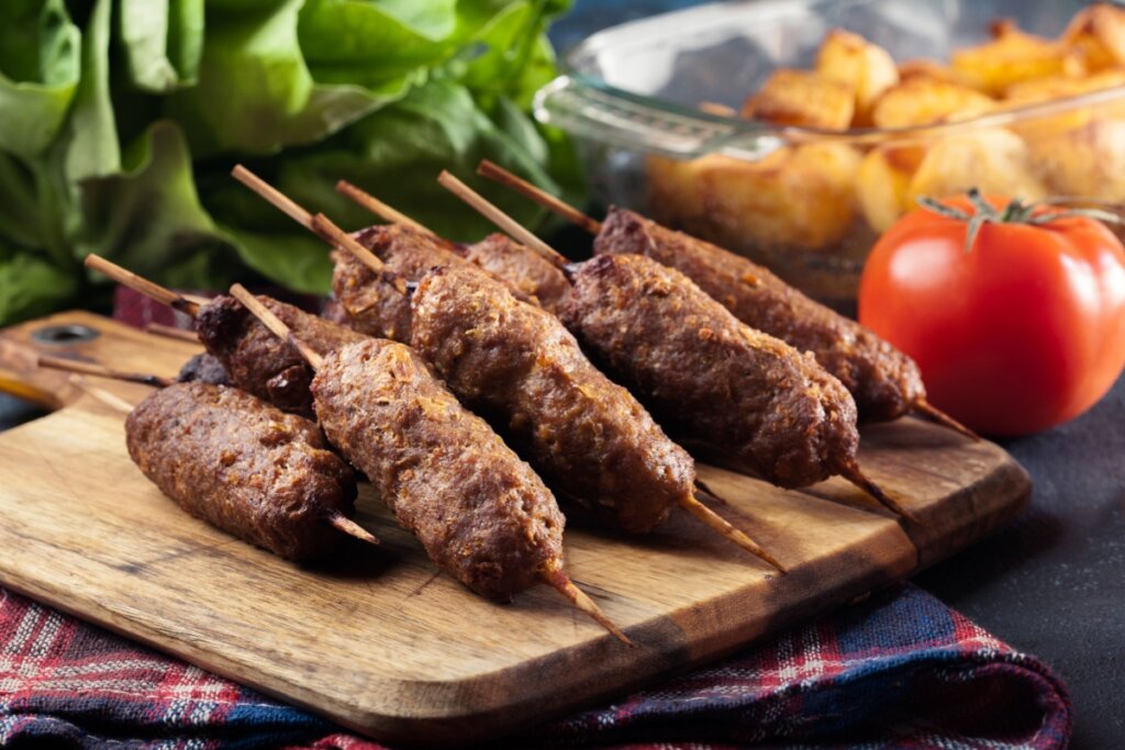 Kafta servida em tábua de madeira em cima de mesa 