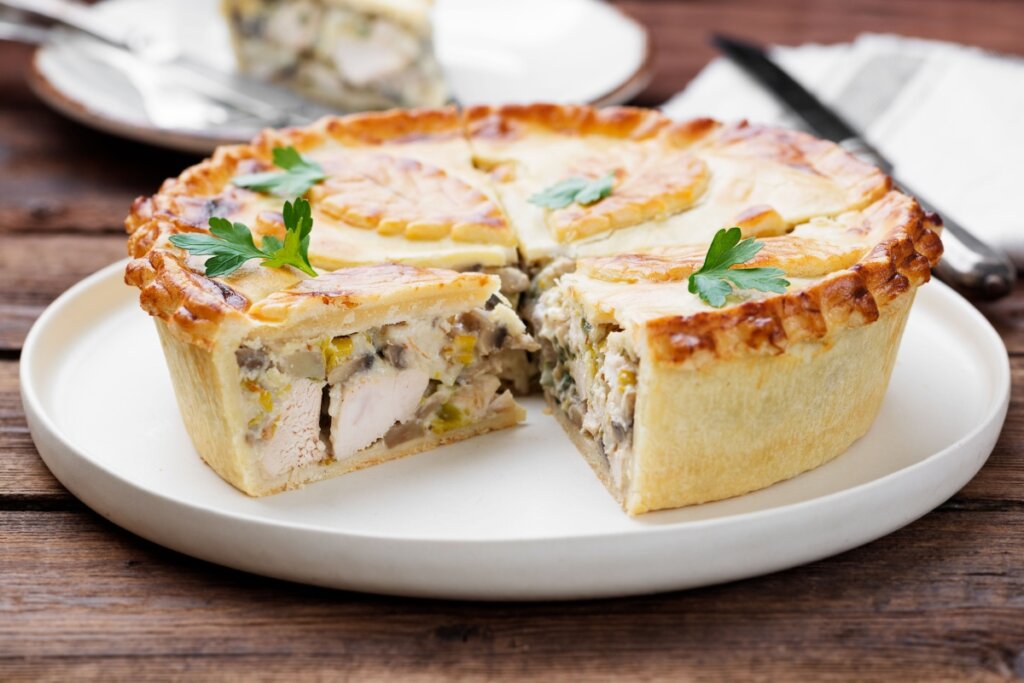 Torta de frango com cogumelos cortada em fatias sobre um prato branco