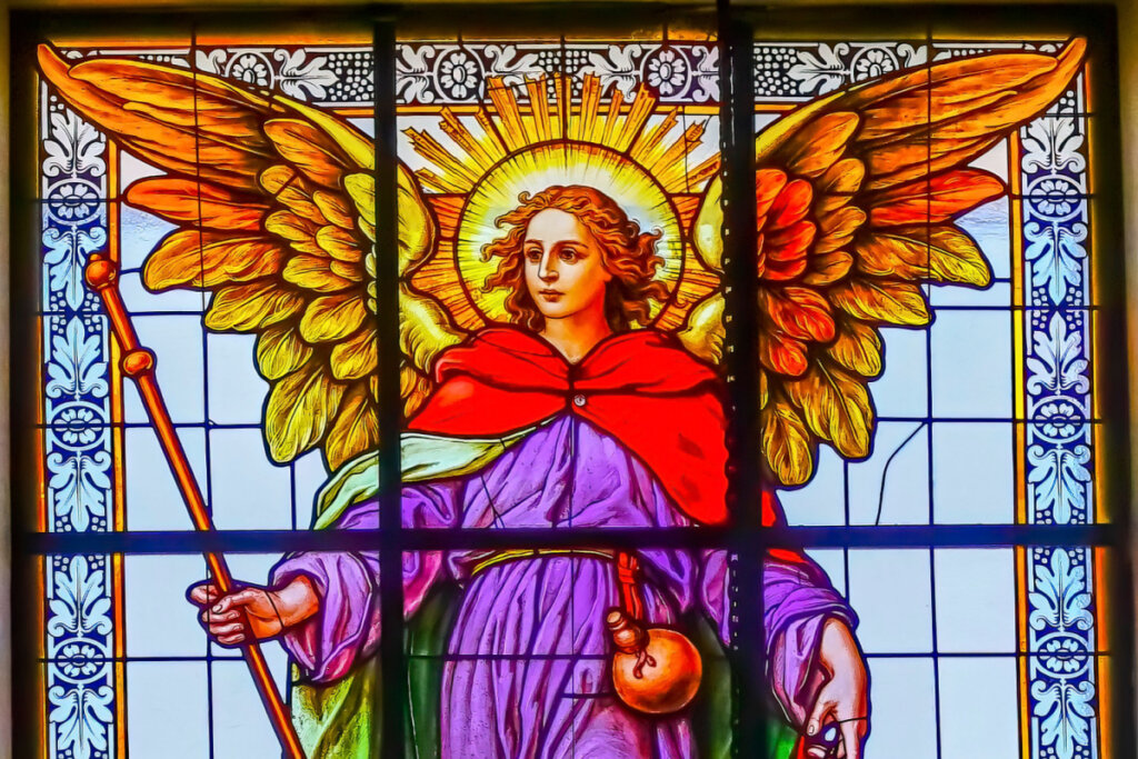 Vitral do Arcanjo Rafael com asas amarela, capa vermelha e roupa roxa