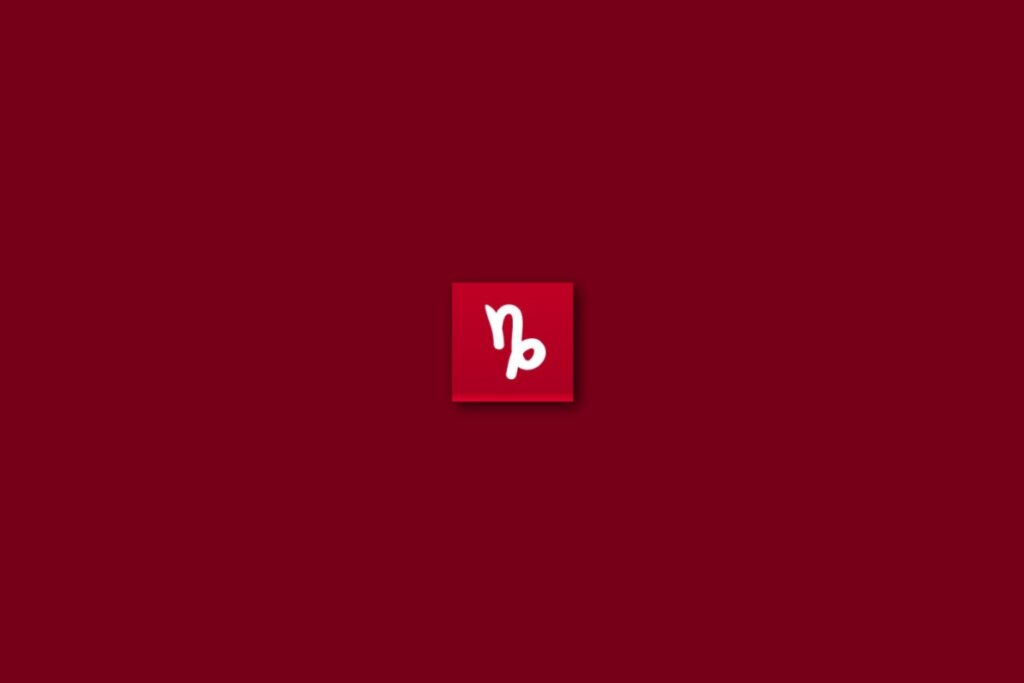 Ilustração branca do signo de capricórnio em um fundo vermelho