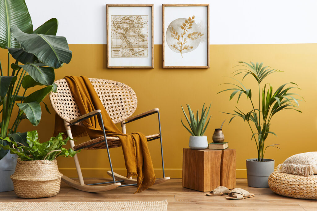 Composição elegante do interior da sala de estar com poltrona e design aconchegante. parede em tom amarelo. vasos com plantas verdes