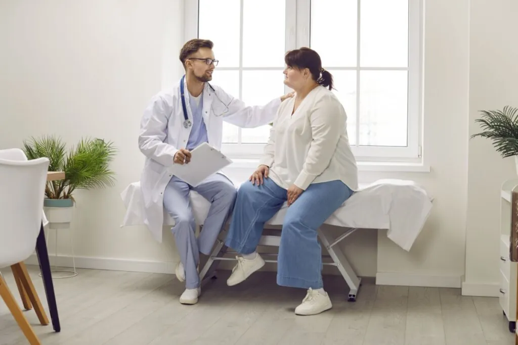 Médico segurando ombro de paciente obesa