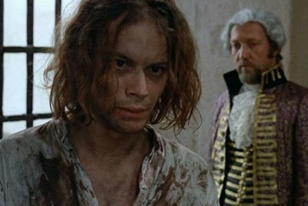 Cena do filme "Os Inconfidentes". Dois homens estão conversando, um com semblante preocupado e o outro atordoado