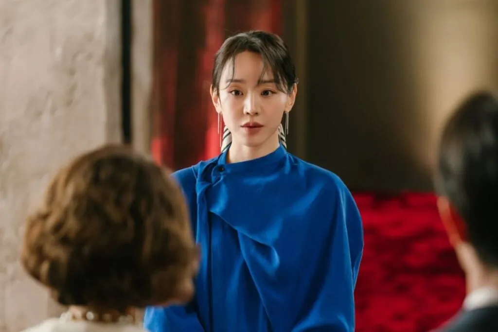 Cena da protagonista de "A Arte de Sarah" em pé e usando roupa azul 