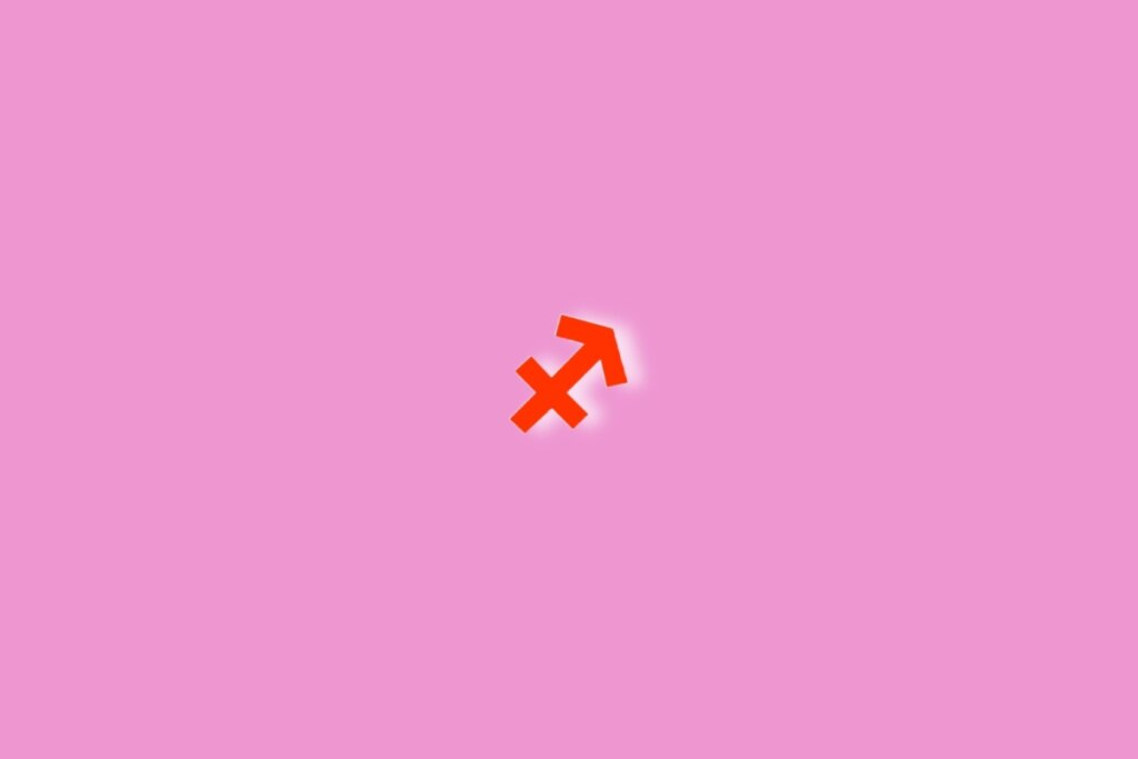Fundo rosa com o símbolo do signo de sagitário em vermelho no centro da imagem. Luz branca ao redor dele
