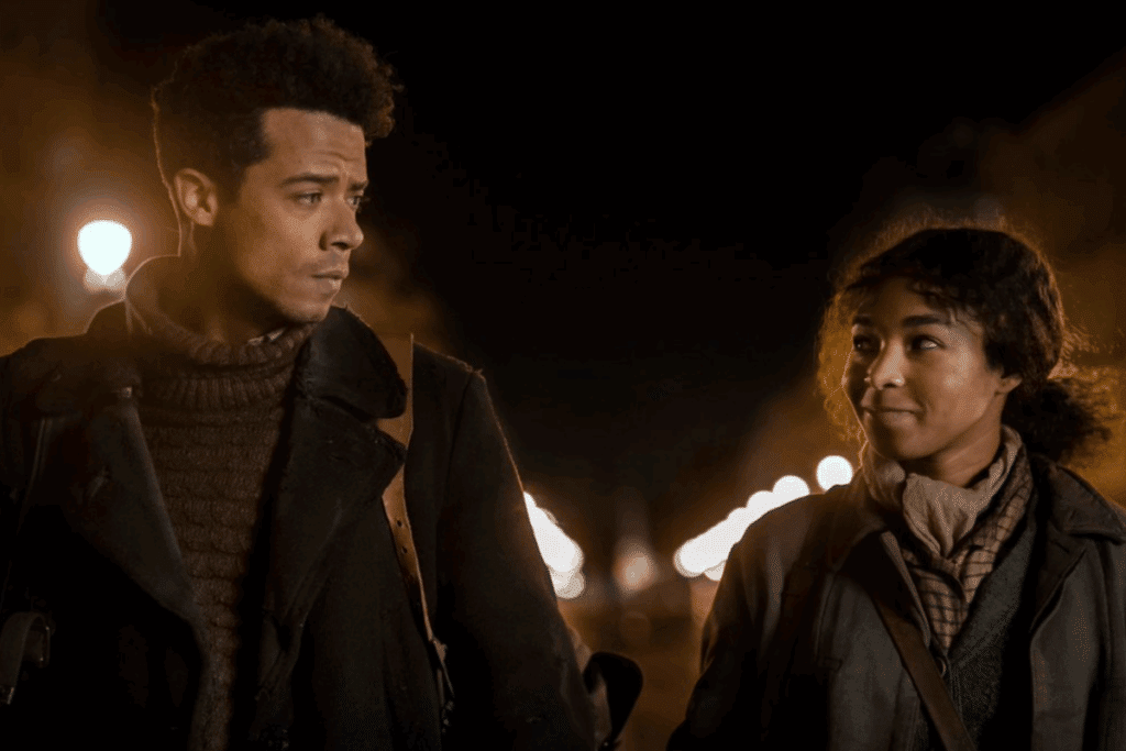 Duas pessoas caminhando à noite por uma rua iluminada