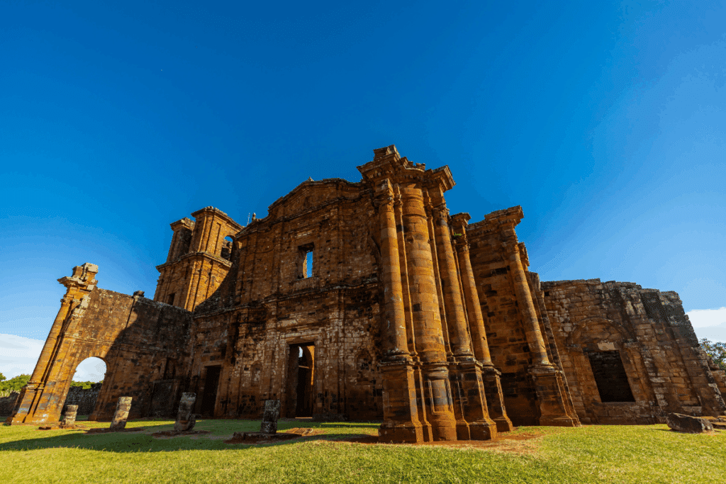 Ruínas históricas de pedra em São Miguel das Missões (RS), destacando a imponente fachada da antiga igreja jesuíta sob céu azul límpido.